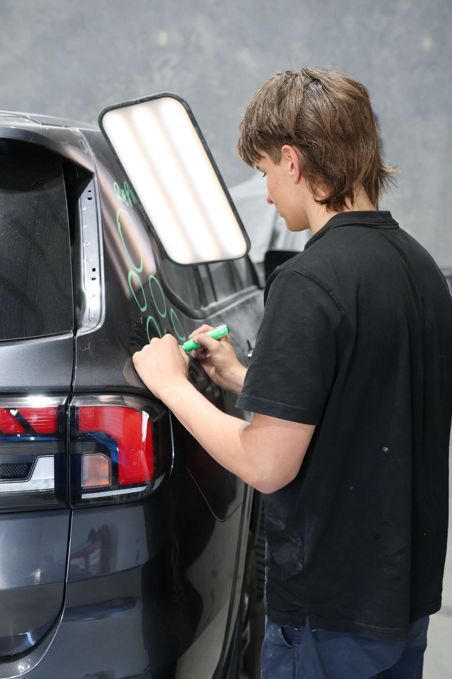 Close-up of dent mapping on a dark panel during damage assessment at MRP Automotive